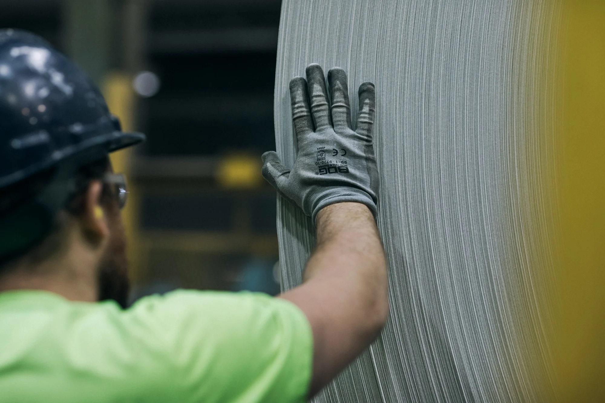 Técnico con casco de seguridad trabajando en planta de manufactura