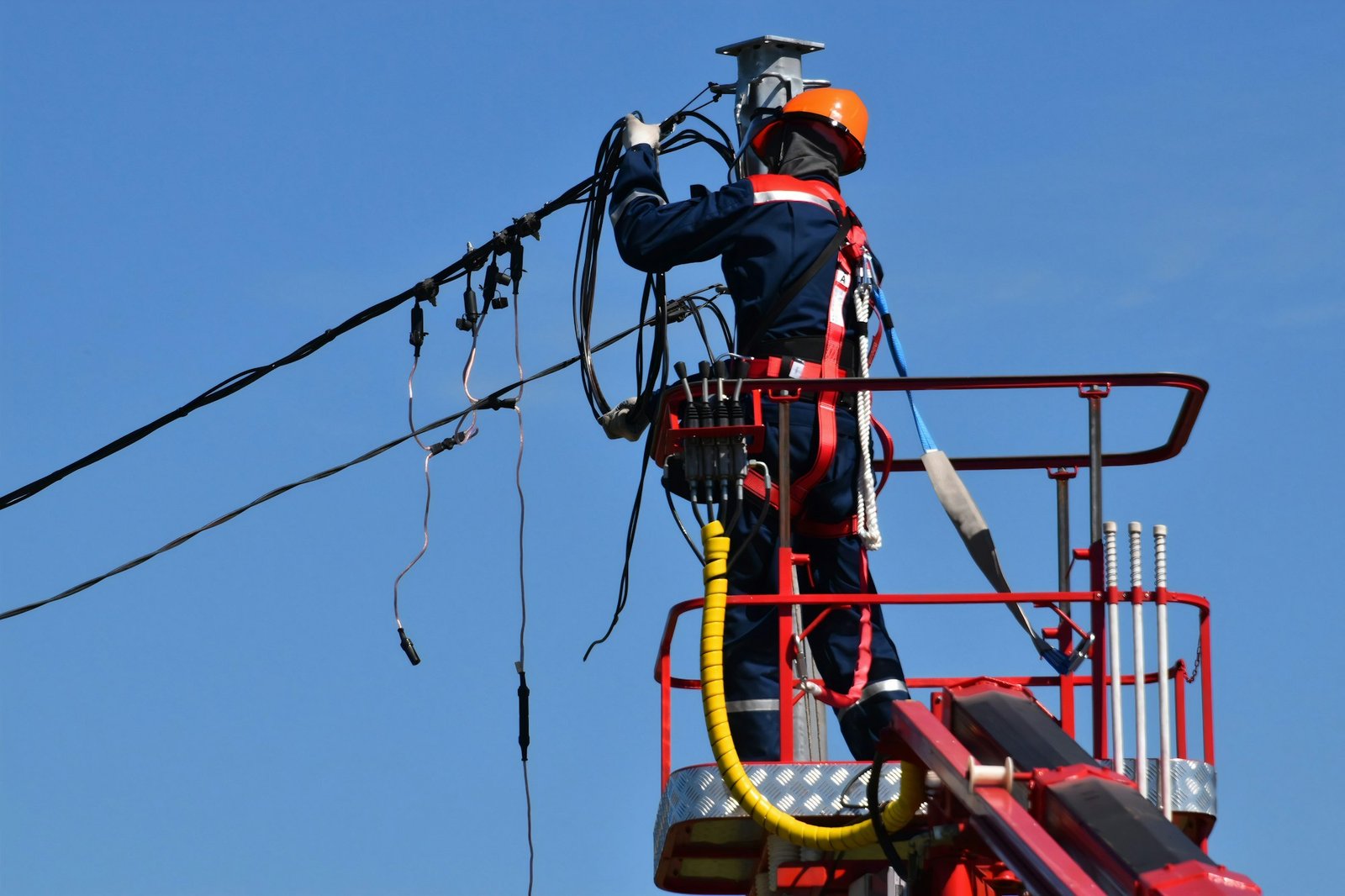Técnico en plataforma elevada trabajando en líneas de alta tensión