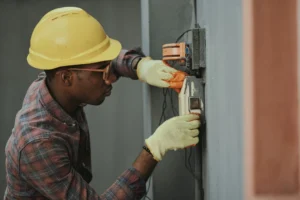 Electricista instalando cableado con casco amarillo