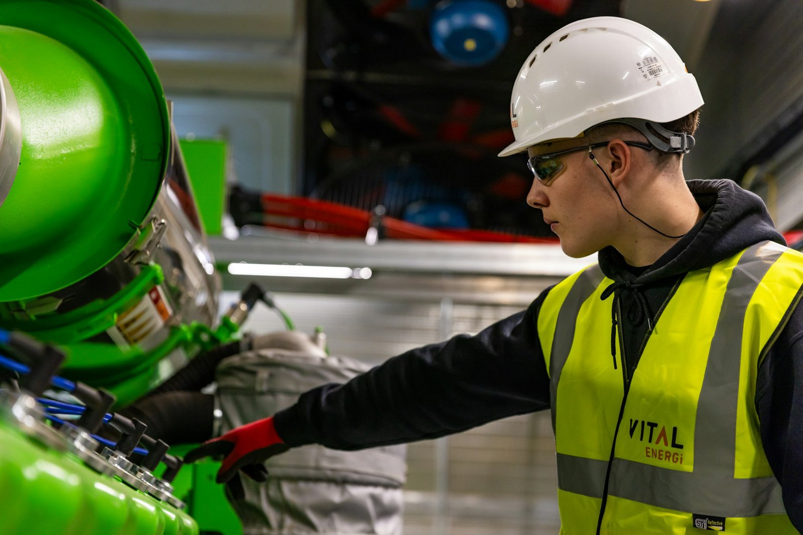 Técnico con casco trabajando en máquina industrial