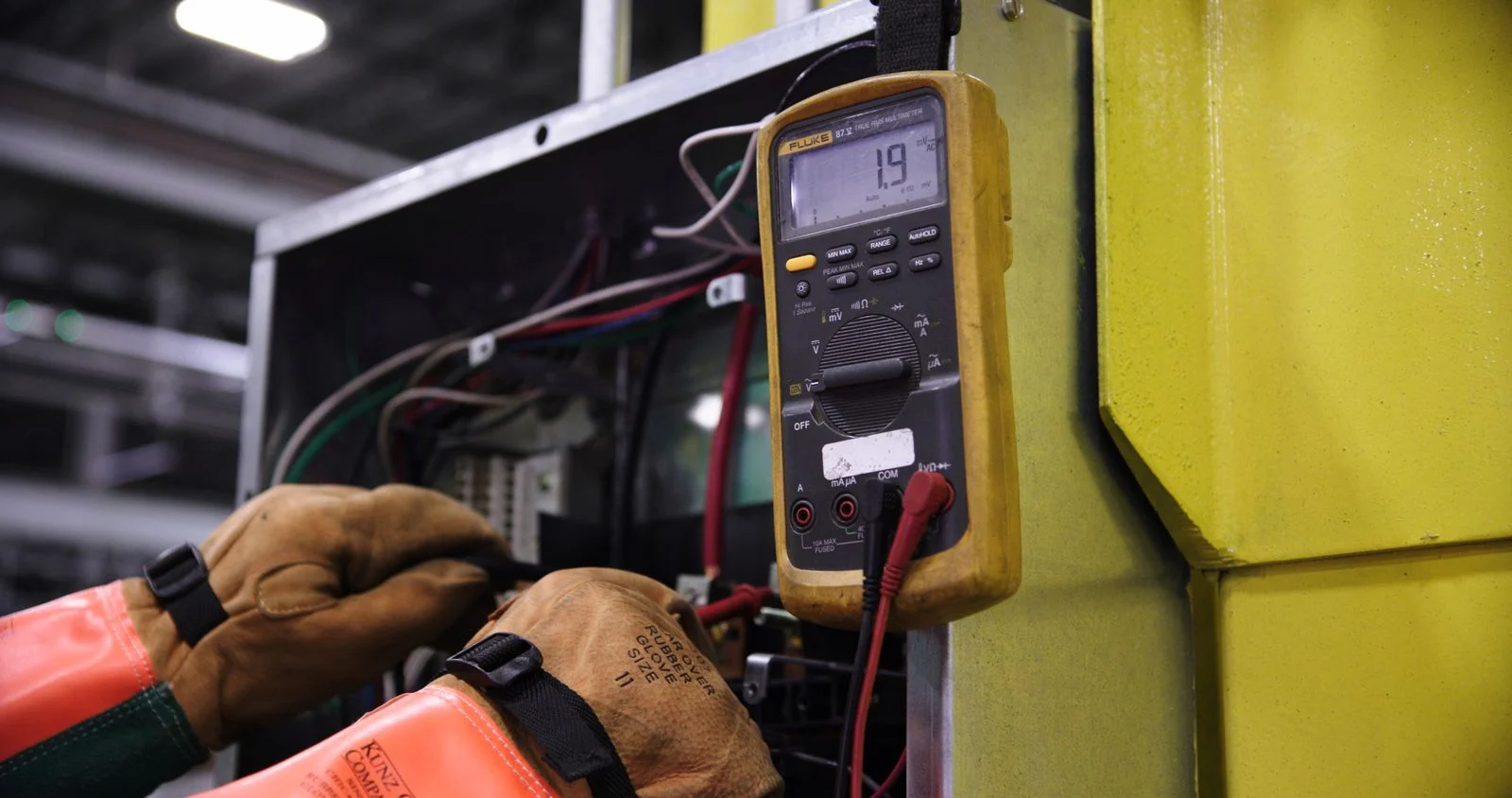 Técnico midiendo con multímetro en tablero industrial para verificar la demanda máxima en GDMTH