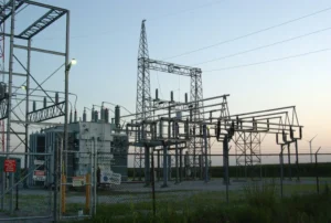 Subestación eléctrica con transformador de potencia y estructuras de media tensión al atardecer